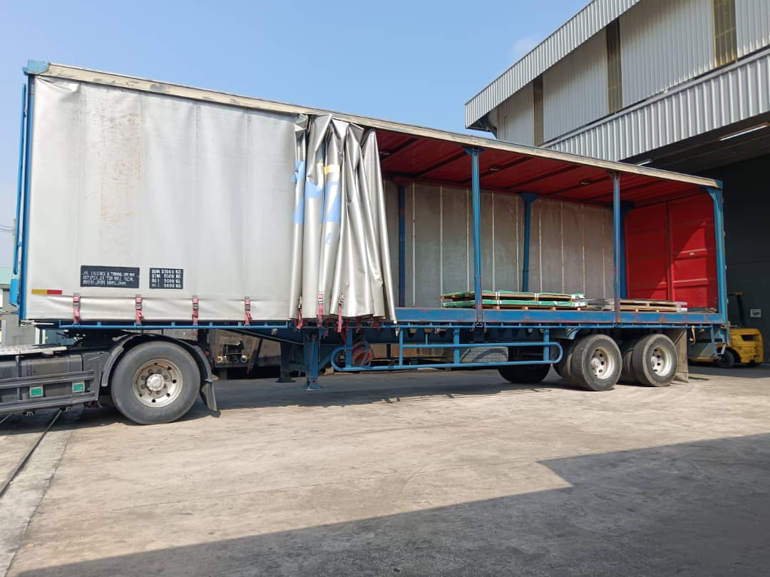 Curtain-sided truck at a warehouse loading bay